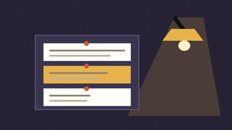 Desk lamp lighting pinned outline cards on a dark board